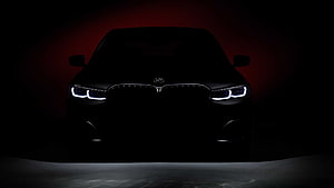 BMW 7 Series Front Facade With Illuminated Headlights Against Dark Red Backdrop HD wallpaper
