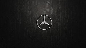 Mercedes-Benz Three-Pointed Star Emblem on Dark Textured Leather Surface HD wallpaper