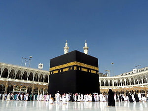 The Kaaba in Mecca with Pilgrims Performing Tawaf Under a Clear Blue Sky HD wallpaper