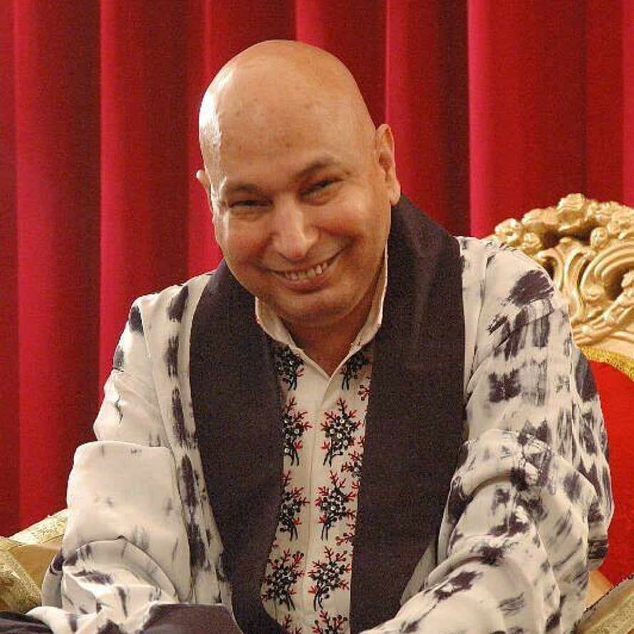 Portrait of a smiling bald man in a patterned shirt and dark vest seated before a red curtain, Guruji Chatarpur, #guruji HD phone wallpaper