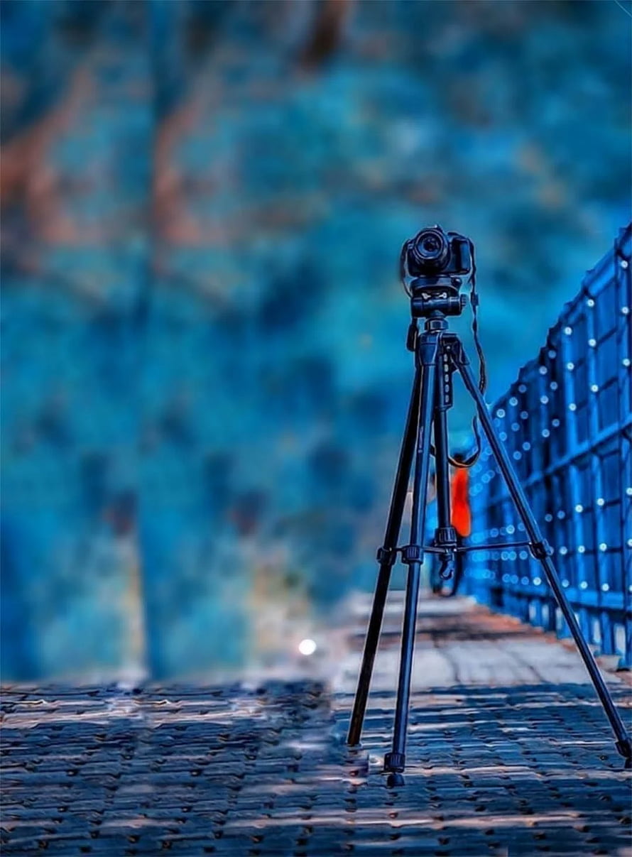 DSLR Camera on Tripod on Cobblestone Path with Blue Bokeh Background HD phone wallpaper