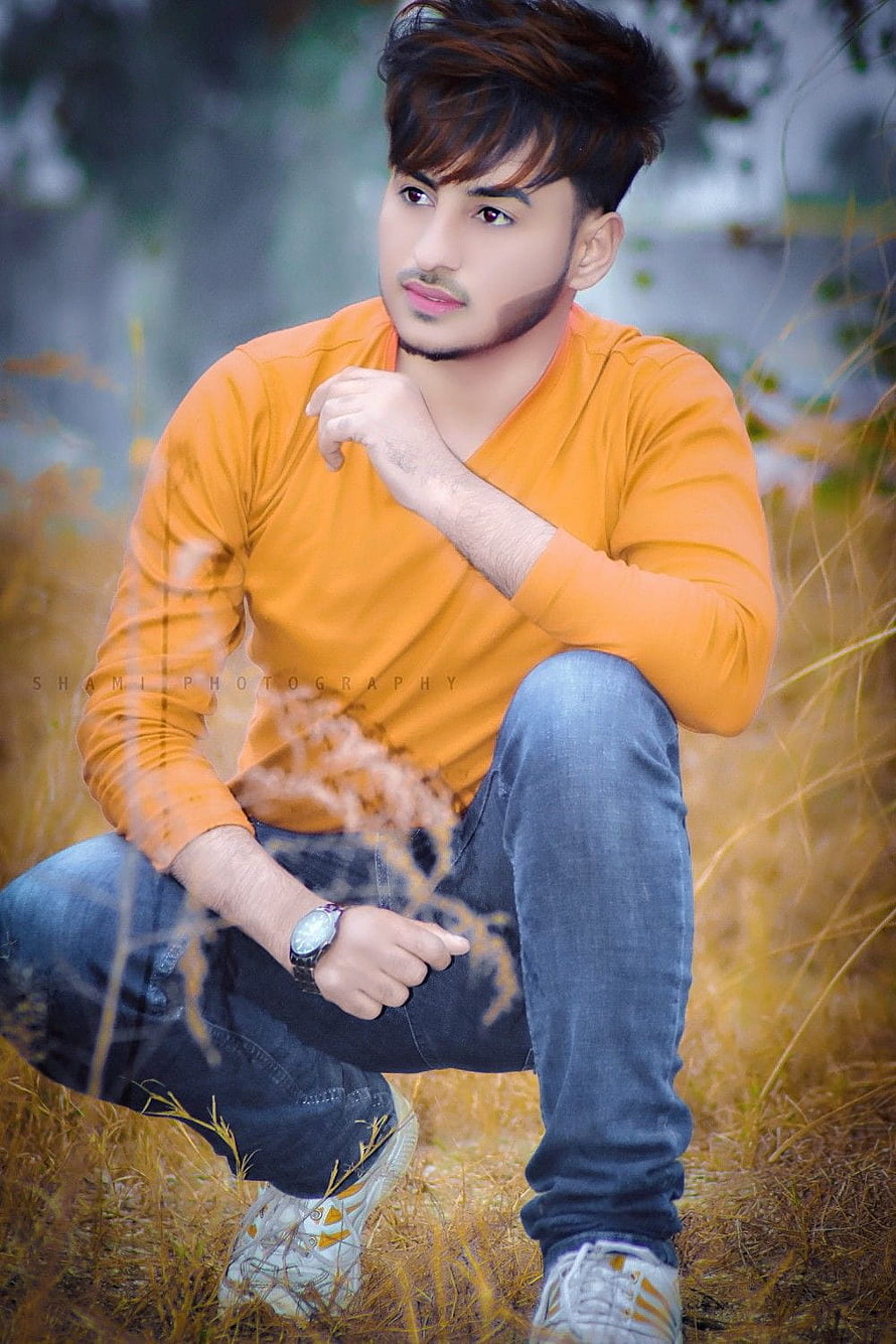 Handsome Young Man in Orange Shirt and Jeans Crouching in a Field of Dry Grass, Stylish boys Whatsapp DP Profile Pics, whatsapp dp boys HD phone wallpaper