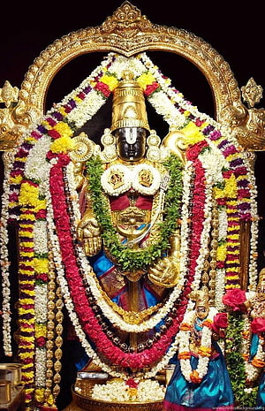 Lord Ayyappa adorned with vibrant flower garlands and golden ornaments in a temple shrine HD phone wallpaper