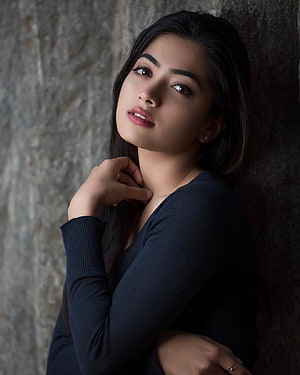 Rashmika Mandanna Portrait Against Textured Stone Wall in Dark Top HD phone wallpaper