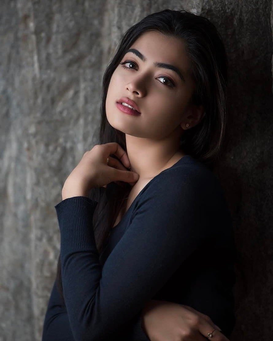 Rashmika Mandanna Portrait Against Textured Stone Wall in Dark Top HD phone wallpaper