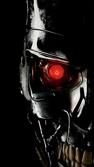 Close-up of the Terminator endoskeleton with glowing red optical sensor against a dark background HD phone wallpaper