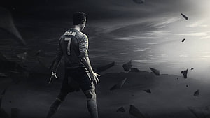 Cristiano Ronaldo in dark jersey standing in a dramatic monochrome landscape with floating debris HD wallpaper