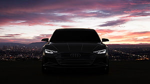 Audi A7 Silhouette Against Vibrant Sunset Sky With City Lights Below HD wallpaper