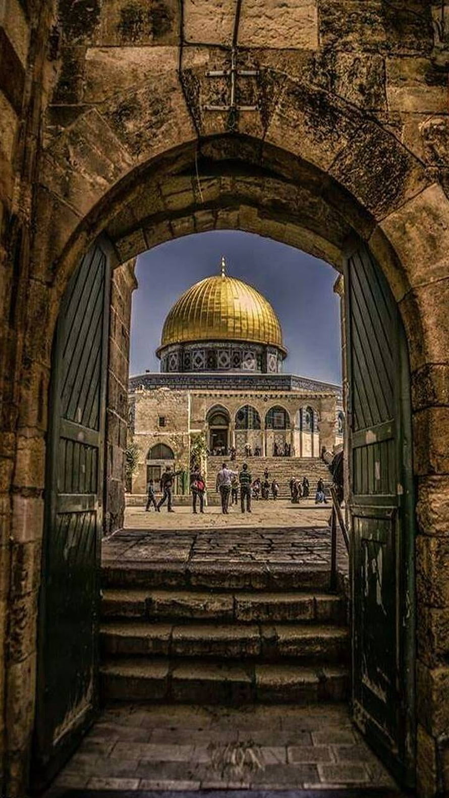 Dome of the Rock in Jerusalem viewed through an ancient stone archway with green wooden doors HD phone wallpaper