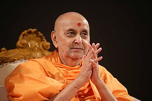 Pramukh Swami Maharaj in Orange Saffron Robes with Hands in Prayer HD wallpaper