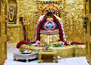 Somnath Mahadev Temple Shrine with Golden Carvings and Flower Offerings HD wallpaper