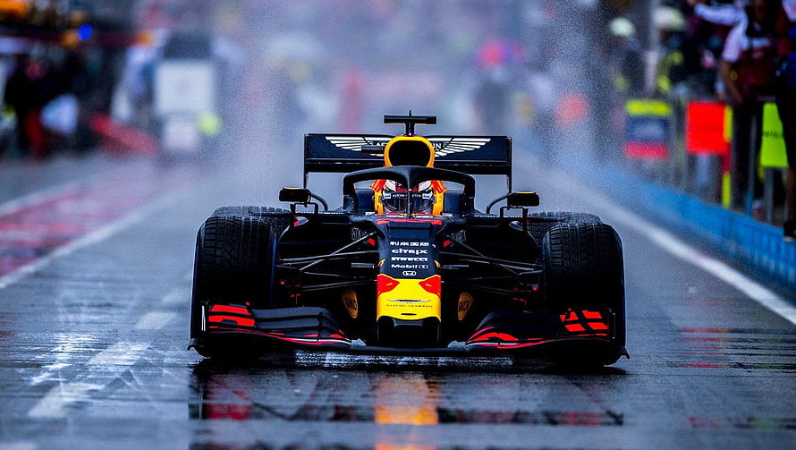 Red Bull Racing Formula 1 car speeding on a wet track during a rain-soaked race HD wallpaper