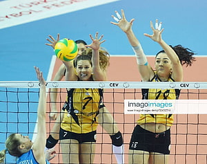 Zehra Gunes and teammates block a volleyball at the net during a CEV match HD wallpaper