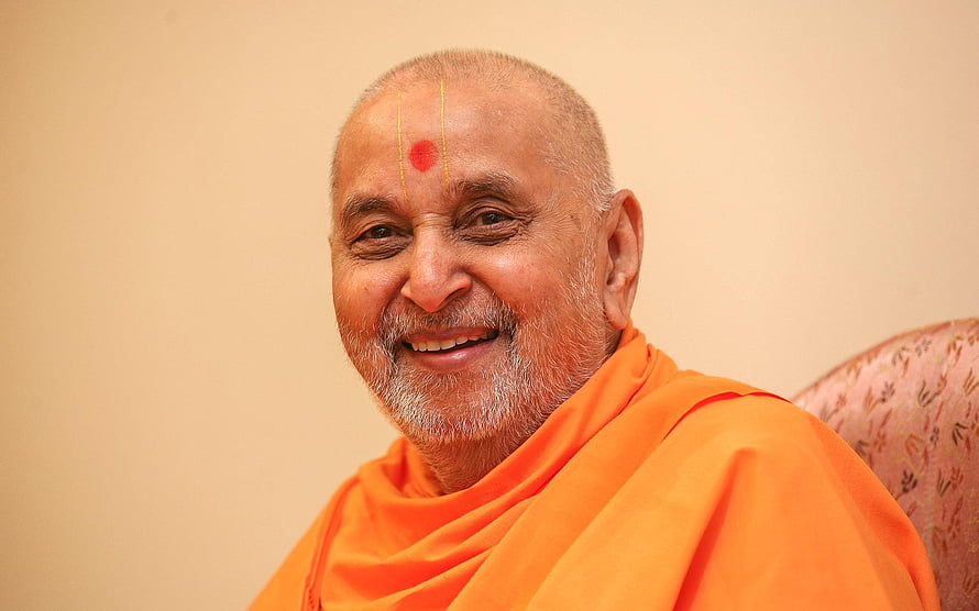 Portrait of a smiling elderly Indian spiritual leader wearing orange robes and a tilak HD wallpaper