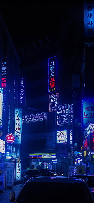 Neon-lit Korean street at night with glowing signs and cars HD phone wallpaper