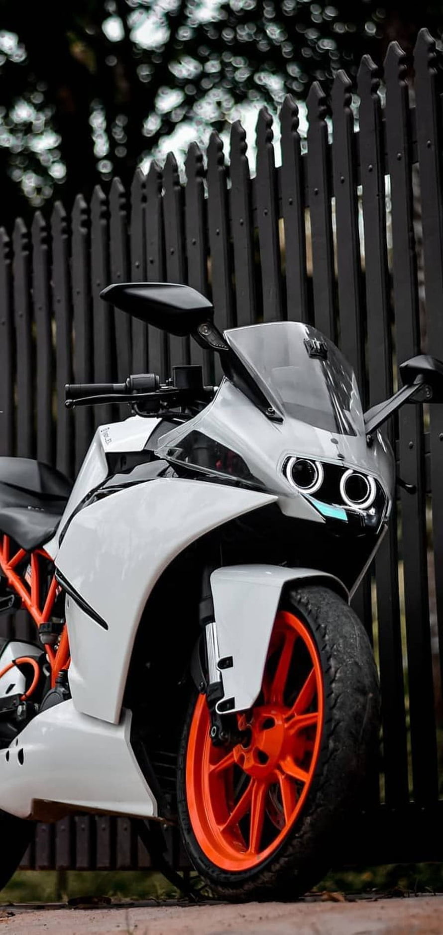 White KTM RC 390 Motorcycle with Orange Wheels and Black Fence Background HD phone wallpaper