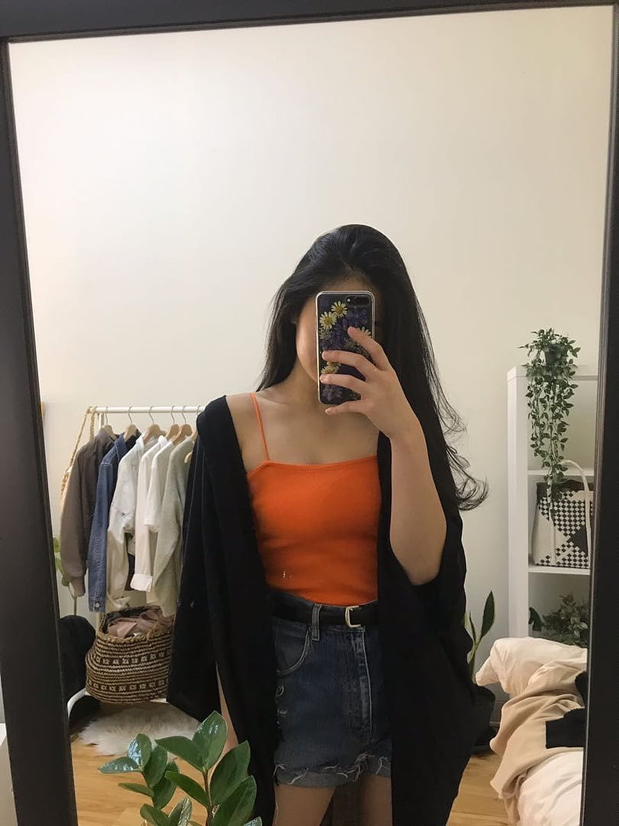 Alma Hussein mirror selfie in orange camisole, denim shorts, and black cardigan HD phone wallpaper