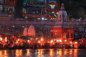 Ganga Aarti Ceremony at Haridwar Ghat with Flaming Torches and Temple Shikharas HD wallpaper