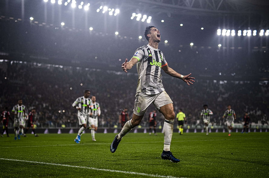 Cristiano Ronaldo Celebrating in Juventus Kit at a Night Football Match HD wallpaper