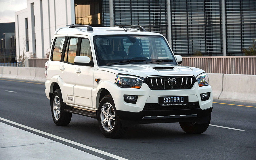 White Mahindra Scorpio SUV Driving on Urban Road HD wallpaper
