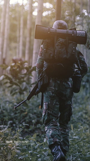 Soldier in Camouflage Uniform Walking Through Dense Forest with Rifle and Backpack HD phone wallpaper