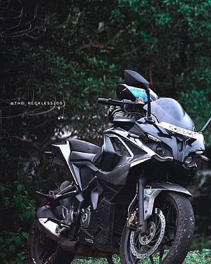 Bajaj Pulsar RS 200 sport motorcycle parked in a lush green forest setting HD phone wallpaper