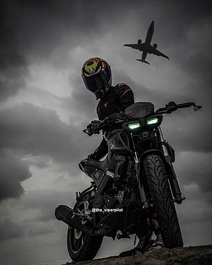 Motorcyclist on Black Bike with Airplane in Stormy Sky HD phone wallpaper