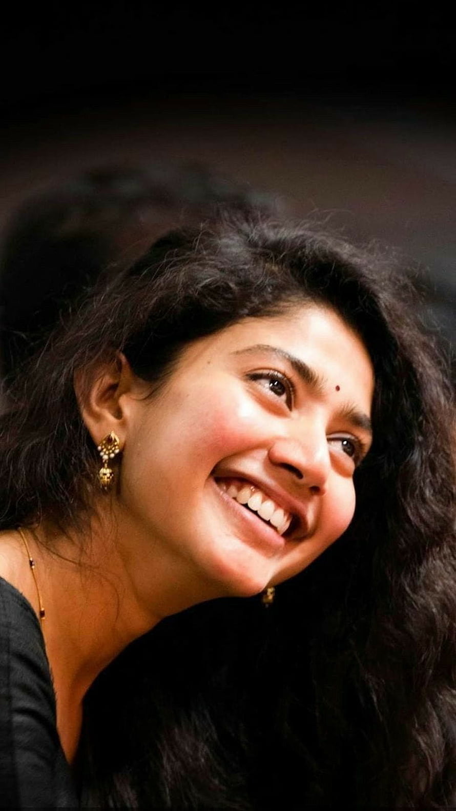 Portrait of a smiling woman with long dark wavy hair and gold earrings, Actress Sai Pallavi HD phone wallpaper