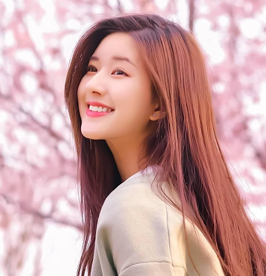 Zhao Lusi smiling portrait with long hair against a soft pink cherry blossom background HD phone wallpaper