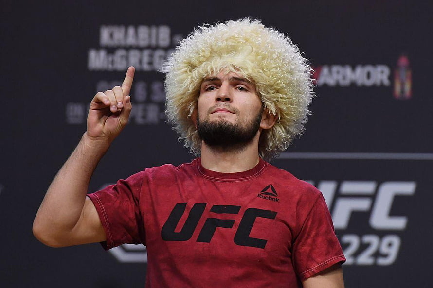 Khabib Nurmagomedov wearing traditional papakha hat pointing up at UFC 229 press conference HD wallpaper