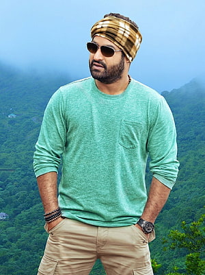 Jr NTR in Green Shirt and Plaid Headband Against Misty Mountain Scenery HD phone wallpaper