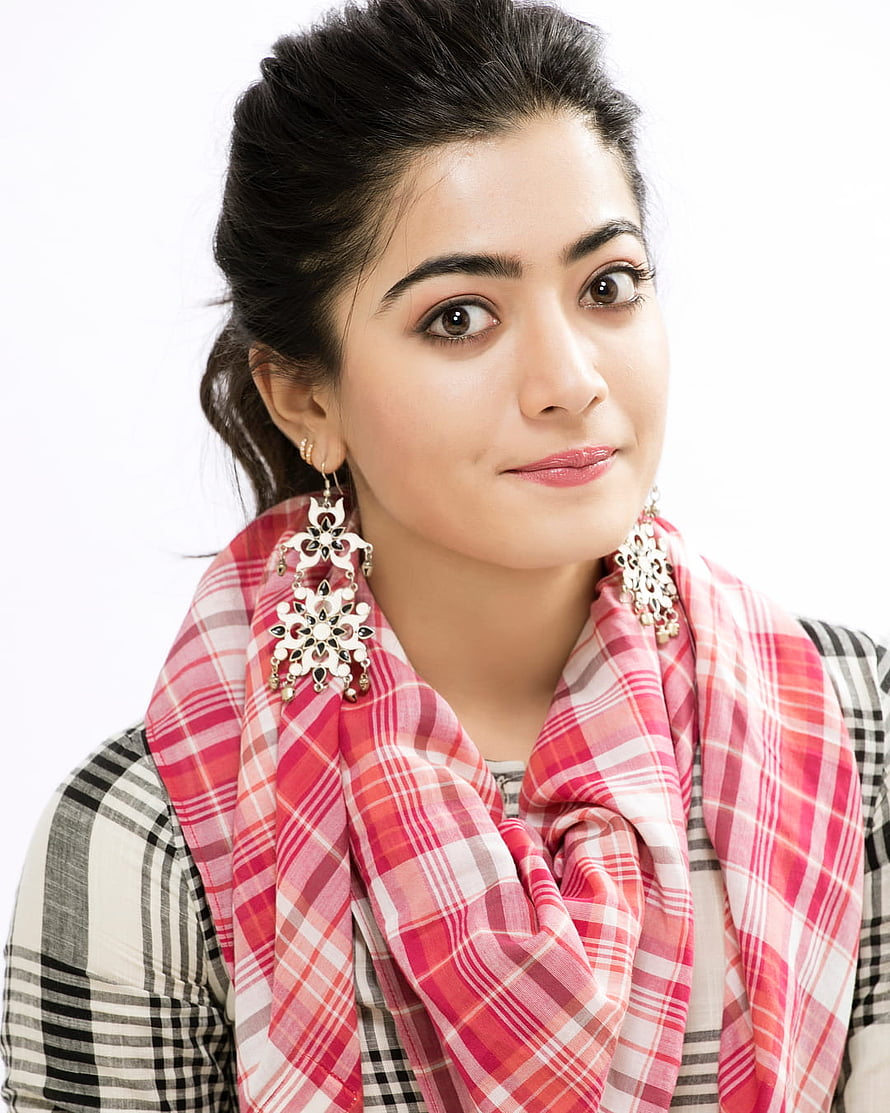 Portrait of a woman wearing a pink plaid scarf and large ornate earrings against a white background, Rashmika Mandanna and , Cute, rashmika mandanna HD phone wallpaper