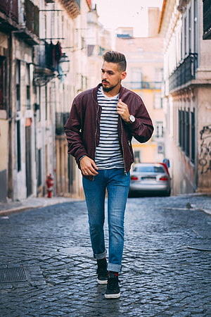 Man in maroon bomber jacket and striped shirt walking on cobblestone street, men and women fashion models, #Men HD phone wallpaper