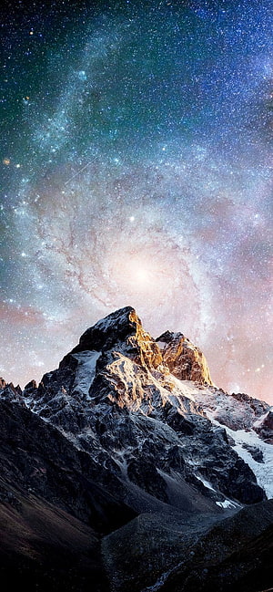Majestic Snow-Capped Mountain Peak Under a Vibrant Milky Way Galaxy Night Sky HD phone wallpaper