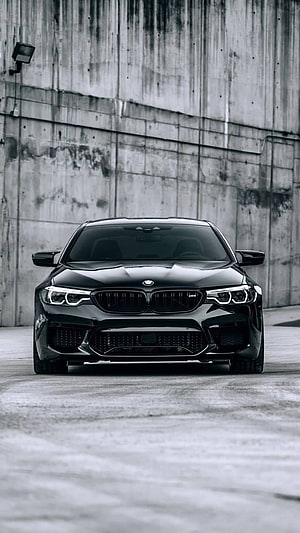Black BMW M5 Competition Front View Against Concrete Wall HD phone wallpaper