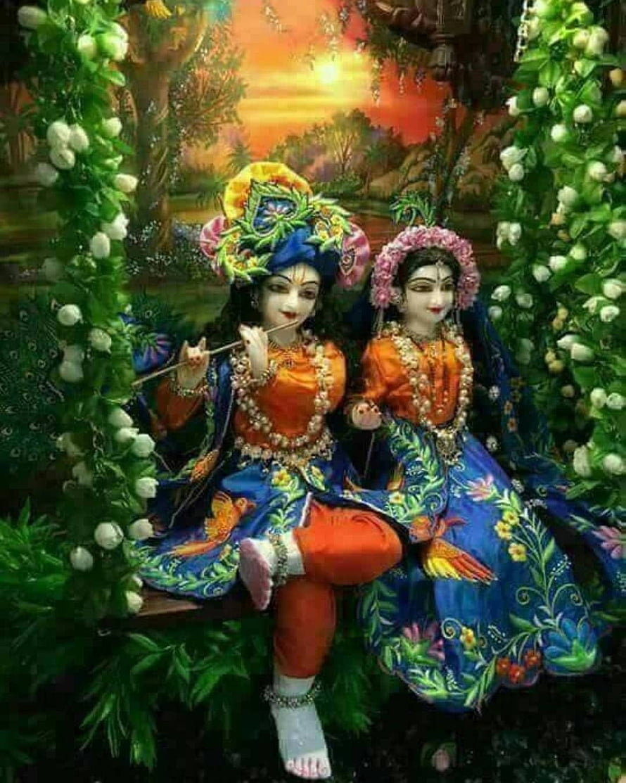 Radha Krishna Sitting on Swing with Peacock Feathers and Floral Garlands HD phone wallpaper