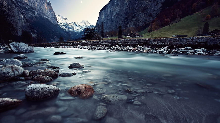 Serene Alpine River Flowing Through Rocky Valley With Snow-Capped Mountains HD wallpaper