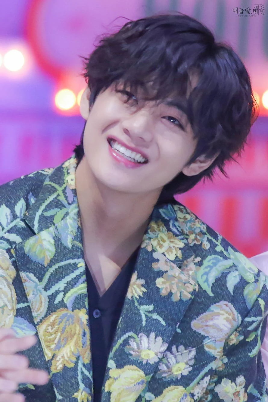 Kim Taehyung smiling in a floral blazer with dark hair and bright background lights HD phone wallpaper
