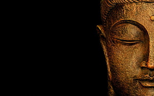 Close-up of a serene Buddha statue face with closed eyes against a dark background HD wallpaper
