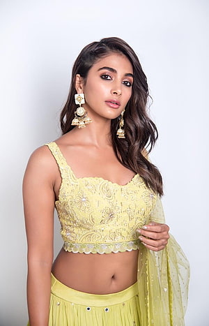 Pooja Hegde in a stunning yellow lehenga choli with intricate embroidery and traditional jewelry HD phone wallpaper