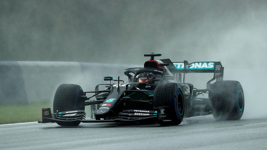Lewis Hamilton Mercedes F1 car kicking up spray on a wet race track HD wallpaper