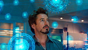 Tony Stark in Iron Man 2 with glowing arc reactor holograms in a high-tech workshop, Tony Stark Discovers a New Element Scene, arc reactor iron man 2 ultra HD wallpaper