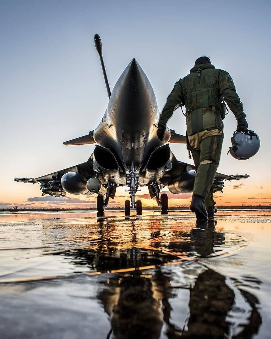 Fighter Pilot Walking Towards Jet on Wet Runway at Sunset HD phone wallpaper