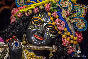 Lord Krishna Murti with Flute, Floral Crown, and Ornate Temple Adornments HD wallpaper