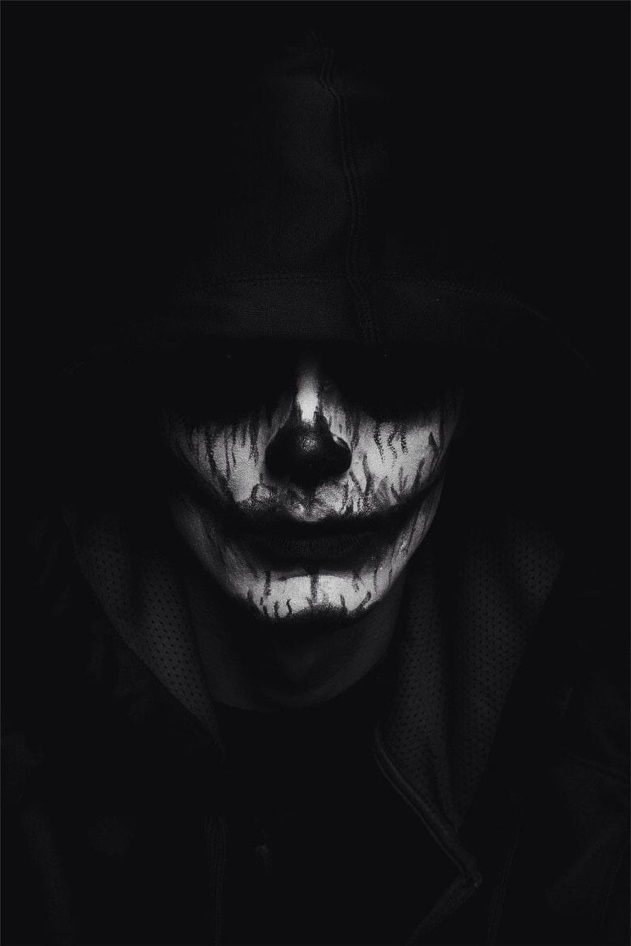 Monochrome Portrait of a Hooded Figure with Distressed Clown Face Paint in Deep Shadow HD phone wallpaper