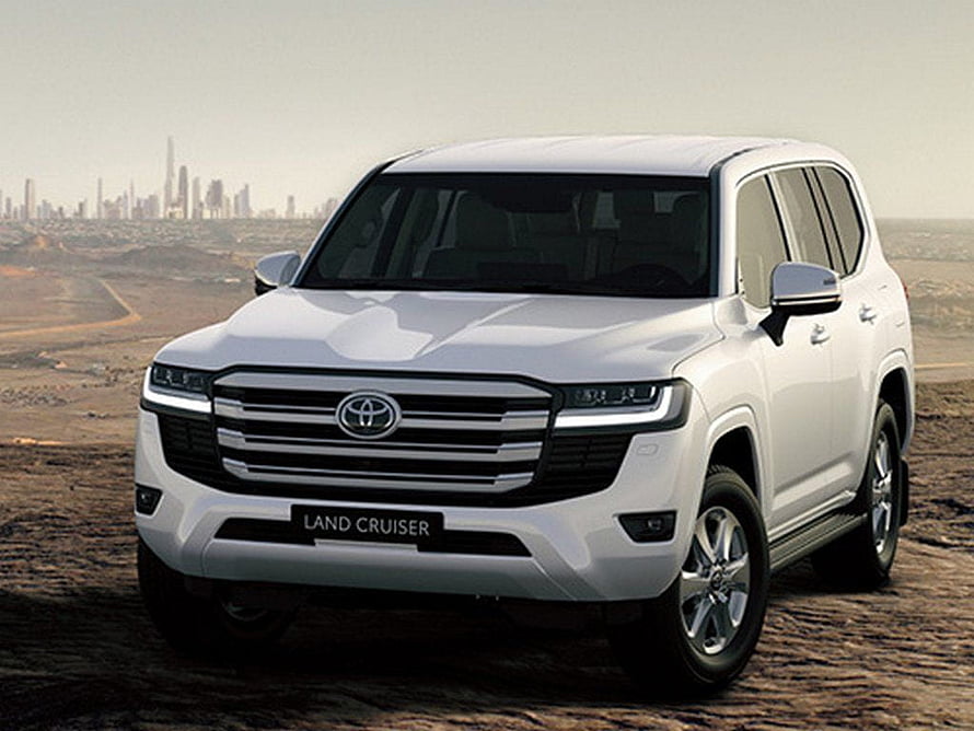 White Toyota Land Cruiser 300 Series SUV Parked on Rocky Desert Terrain with City Skyline HD wallpaper
