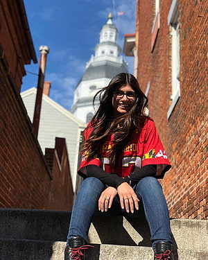Young Woman in Maryland Terrapins Jersey Sitting on Steps with Historic Capitol Dome Background, Mia Khalifa HD phone wallpaper