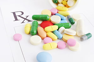 Colorful Prescription Pills and Capsules Scattered on a Medical Rx Document HD wallpaper