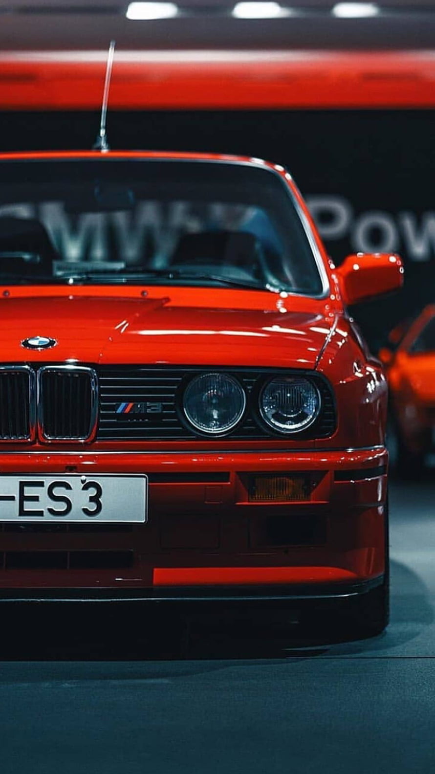Front view of a classic red BMW M3 E30 sports car with iconic grille and headlights HD phone wallpaper