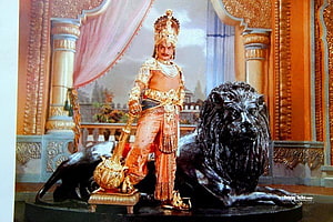 NTR in Royal Attire Standing Beside a Lion Statue in a Palace Setting HD wallpaper